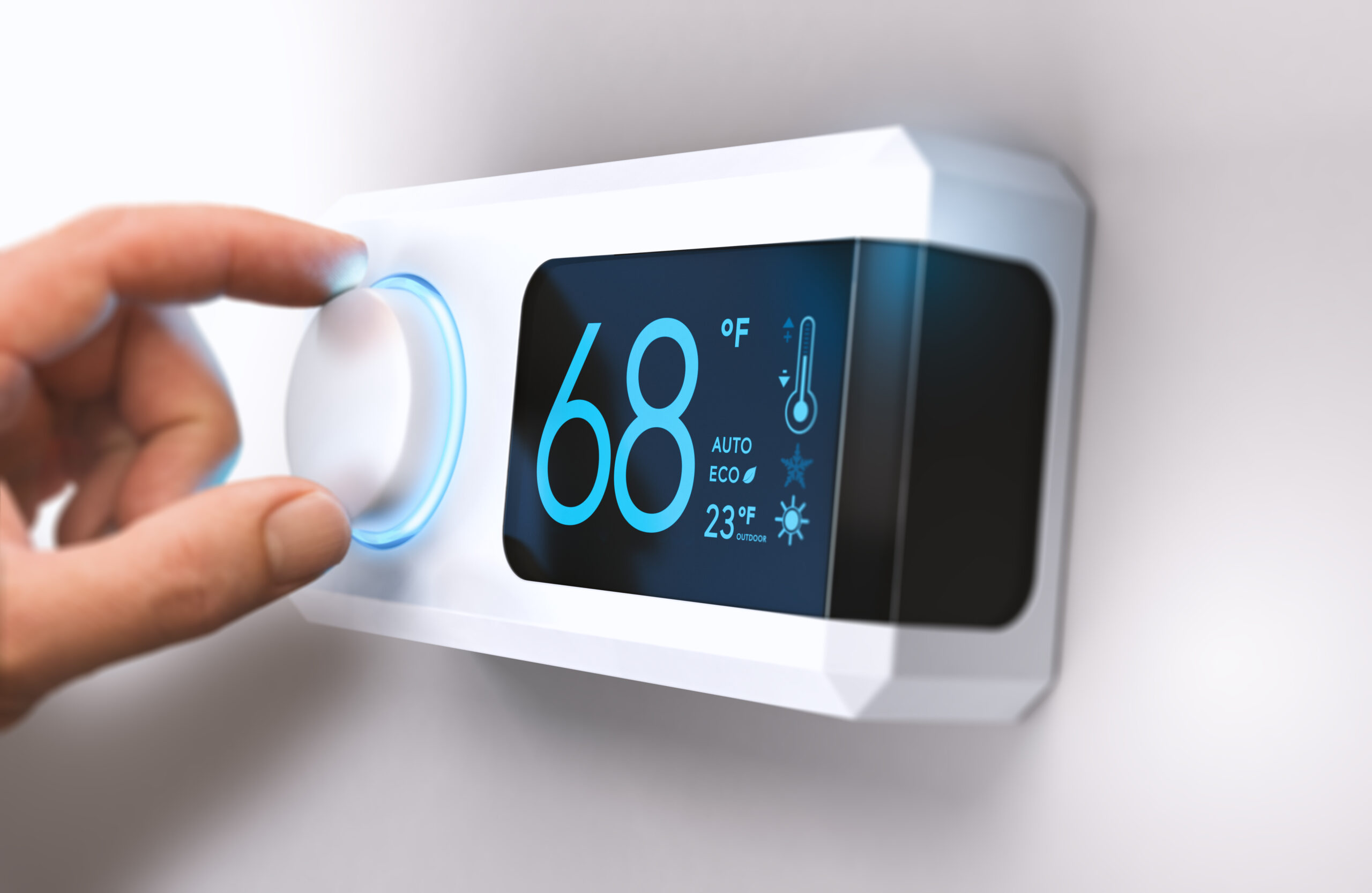 A person adjusting a home thermostat.